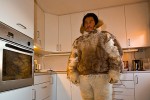 Inuit hunter in traditional clothing, in his modern kitchen