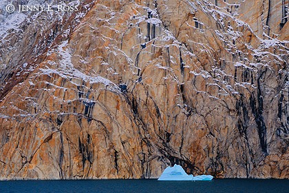 Melting iceberg and rock face with desert varnish, Ofjord